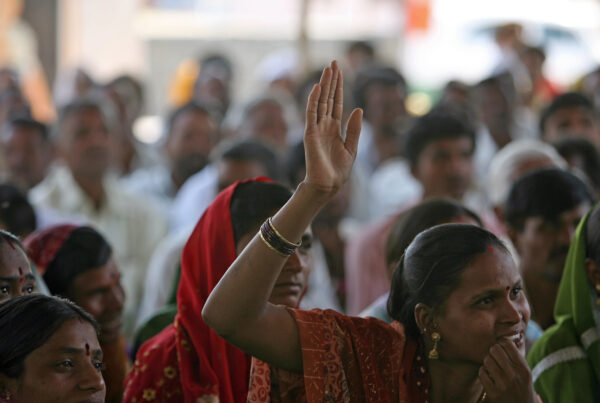 Community meeting. Woman raises hand to speak. Aurangabad, India.